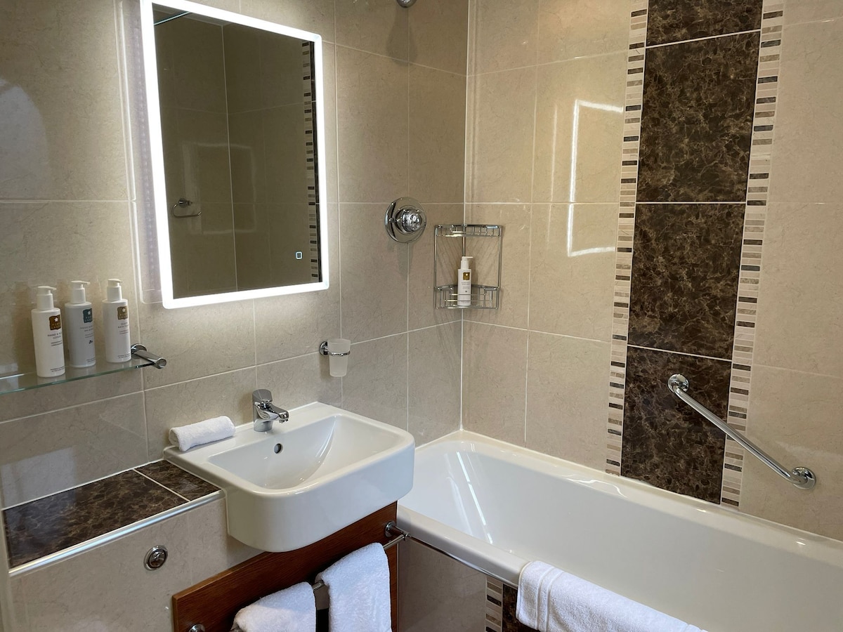 En-suite bathroom with bath and basin